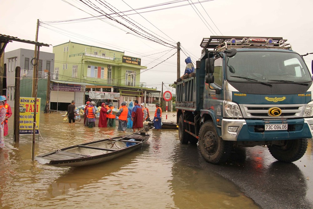   Lực lượng cứu hộ nỗ lực đưa hàng cứu trợ về đồng bào vùng lũ Quảng Bình. (Ảnh: TTXVN)