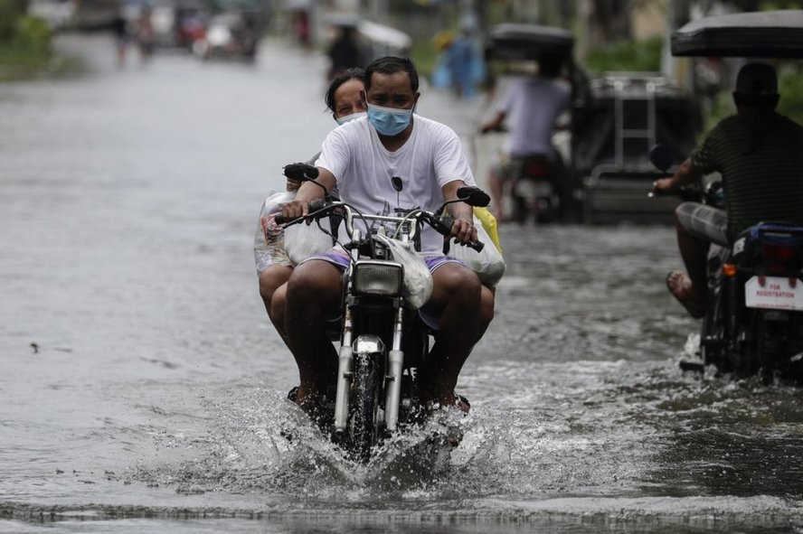 Vài người dân cố lái xe qua đoạn đường ngập nước ở tỉnh Pampanga, phía Bắc Philippines ngày 26/10. Ảnh: AP