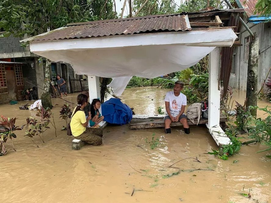 Một vài người dân trong khu vực bị ngập nước ở thị trấn Pola, tỉnh Mindora ngày 26/10. Ảnh: AFP