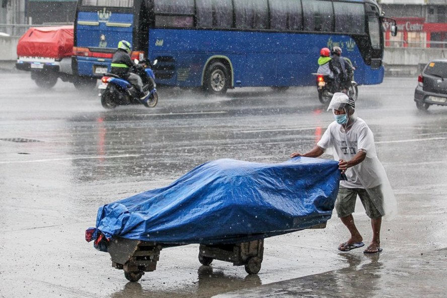 Một người đàn ông đẩy xe hàng khi trời mưa to do bão Molave ở Manila hôm 25/10. Ảnh: Tân Hoa xã.
