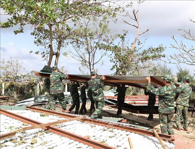 Các chiến sĩ bộ đội giúp thầy cô giáo và học sinh Trường THCS Thị trấn Châu Ổ, huyện Bình Sơn khắc phục hậu quả do cơn bão số 9 gây ra.