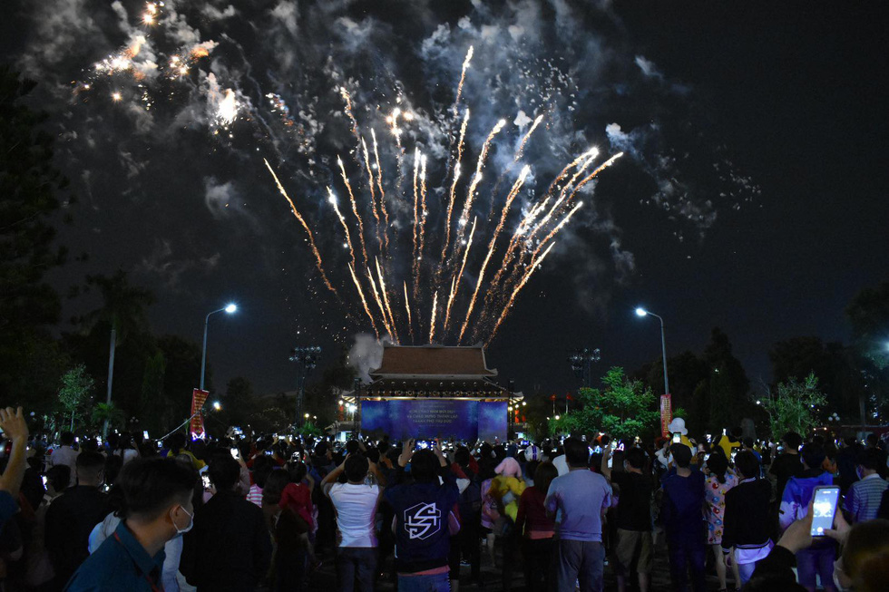 Người dân vây kín trước cổng đền tưởng niệm Bến Nọc chiêm ngưỡng những tràng pháo hoa chào mừng thành phố mới - Ảnh: HOÀNG AN