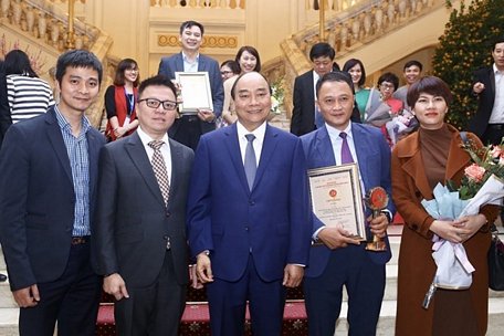 Thủ tướng Nguyễn Xuân Phúc với Phó Tổng giám đốc TTXVN Lê Quốc Minh và các tác giả đạt giải B (thể loại ảnh) thuộc Ban Biên tập Ảnh TTXVN tại lễ trao Giải Búa liềm vàng năm 2019. (Ảnh: Minh Quyết/TTXVN)