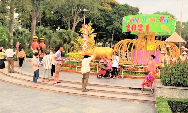 Người dân vui vẻ chụp ảnh bên tiểu cảnh linh vật con trâu vàng đón chào xuân mới.