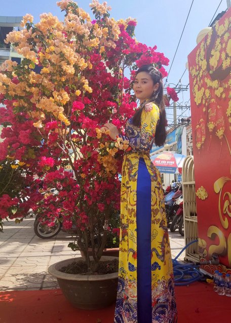 Sinh viên Chittakone Meuangkhoth duyên dáng trong tà áo dài Việt Nam đi chụp hình hoa tết.