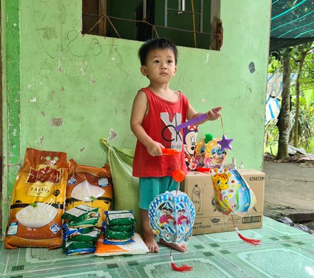 Bé Lê Nguyễn Thuận Khang (con anh Nguyễn Hùng Thuận) bên những phần quà các nhà hảo tâm hỗ trợ.