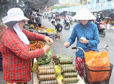Ở một góc chợ Vĩnh Long, quầy bánh tét “mỗi năm chỉ mở bán vào mùng 2 tết” của dì Lư Thị Ánh Đào (Phường 1) bán rất đắt.