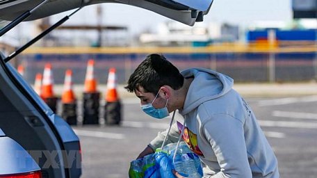  Tình nguyện viên phát nước sạch cho người dân tại Galveston, bang Texas, Mỹ. (Ảnh: AFP/TTXVN)