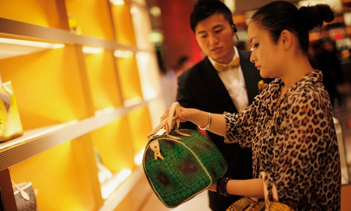 Một người phụ nữ mua sắm tại cửa hàng Louis Vuitton ở trung tâm mua sắm tại Thượng Hải. Ảnh: Reuters