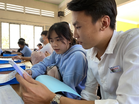 Học sinh Nguyễn Việt Thanh, Nguyễn Thị Trúc Mai cùng xem sách tra cứu nghề nghiệp.