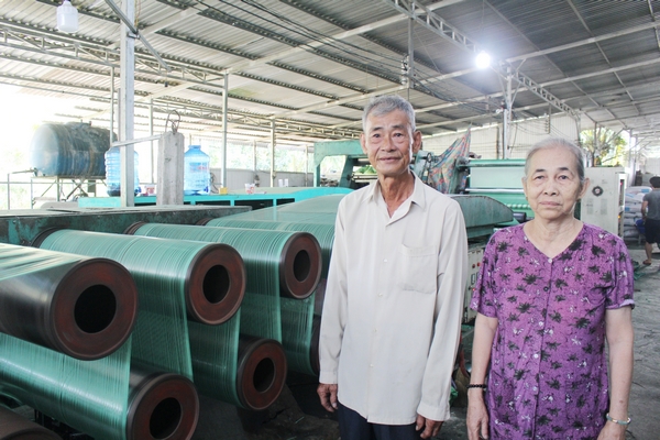 Vợ chồng ông Bùi Văn Bưng bên cơ sở sản xuất bao bì Thêm Phát.