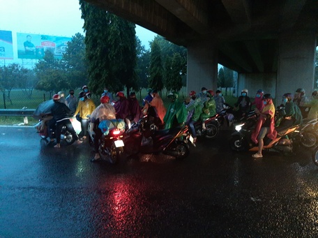 Chiều tối vẫn còn nhiều công dân về quê bằng xe máy trú mưa ở chân cầu vượt Mỹ Thuận.