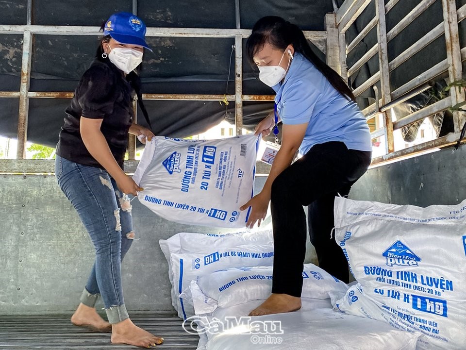 Không ngại vất vả, Giang Thị Diễm Thy (bên phải) cùng đội tình nguyện của Huyện đoàn Trần Văn Thời hỗ trợ vận chuyển nhu yếu phẩm cho bà con nông dân trong mùa dịch trên địa bàn huyện.
