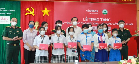 Các đại biểu trao máy tính bảng cho đại điện các em học sinh.