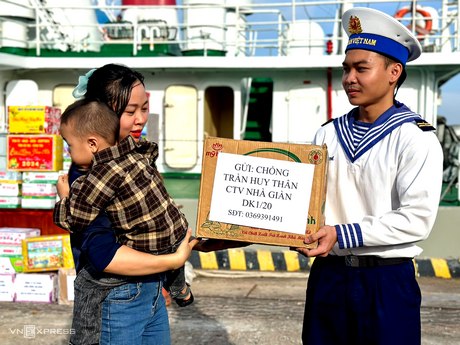 Chị Nguyễn Thị Minh Thương cùng con ra bến cảng nhờ gửi quà đến chồng là Đại uý Trần Huy Thân- Chính trị viên Nhà giàn DK1/20.