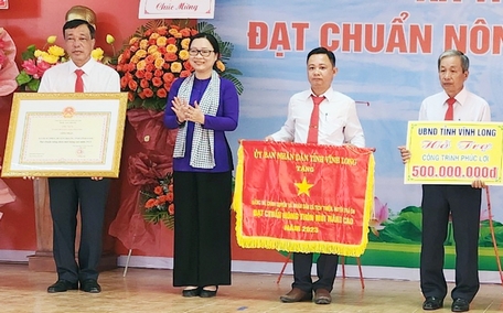 Bà Nguyễn Thị Quyên Thanh- Phó Chủ tịch UBND tỉnh, trao cờ thi đua cấp tỉnh, bằng công nhận xã Tích Thiện đạt chuẩn NTM nâng cao và hỗ trợ công trình phúc lợi trị giá 500 triệu đồng.
