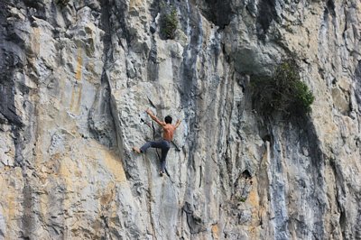 Người nhện Nguyễn Văn Vũ đang đu người giữa vách núi cheo leo không dây bảo hiểm - Ảnh: Tiến Thắng