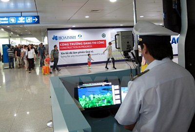 Theo dõi thân nhiệt hành khách tại sân bay Quốc tế Tân Sơn Nhất, Thành phố Hồ Chí Minh. (Ảnh: Phương Vy/TTXVN).