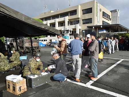 Lực lượng phòng vệ Nhật Bản phân phát lương thực cứu trợ người dân chịu ảnh hưởng của động đất tại Mashiki, tỉnh Kumamoto ngày 17/4. (Nguồn: AFP/TTXVN)