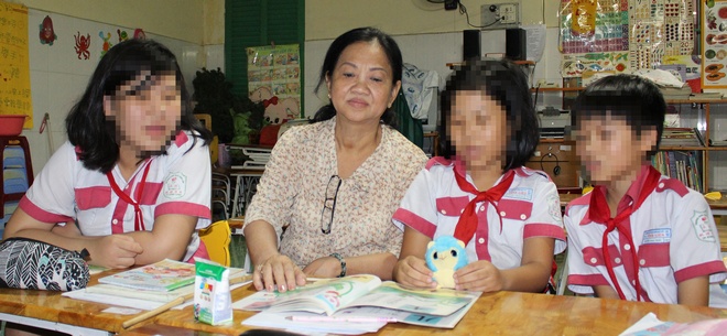 Em Nguyễn Ngọc Tr. (bìa phải) đang học lớp tiếng Hoa, chờ cha mẹ ổn định sẽ rước sang Đài Loan.