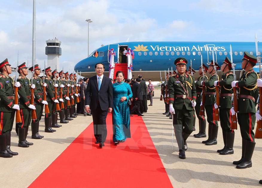 Đại diện Nhà nước Lào cùng cán bộ nhân viên Đại sứ quán Việt Nam và đông đảo kiều bào đón Chủ tịch nước Trần Đại Quang và phu nhân tại sân bay quốc tế Wattay. (Ảnh: Nhan Sáng/TTXVN)