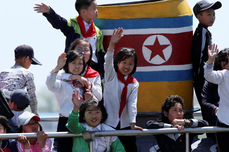 Trẻ em Triều Tiên vẫy tay trong chuyến thăm ở khu vực sông Áp Lục giáp thành phố Đan Đông vùng biên của Trung Quốc. Ảnh: Reuters.