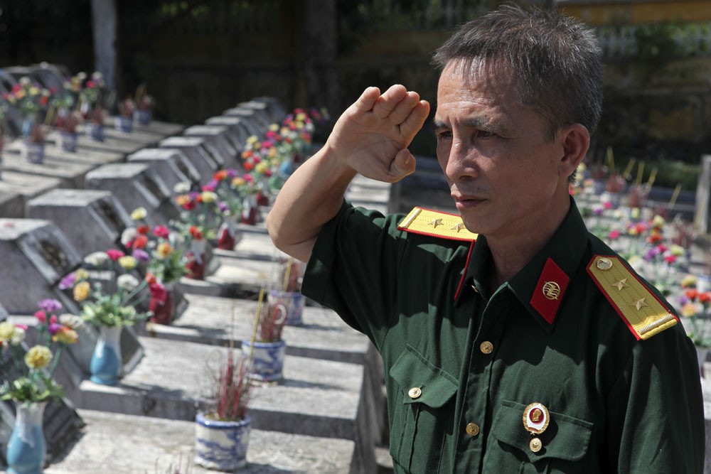 Cựu binh của sư đoàn 356 Phạm Quang Hòa chào đồng đội sau khi thắp hương lên mộ liệt sỹ ở nghĩa trang Vị Xuyên.