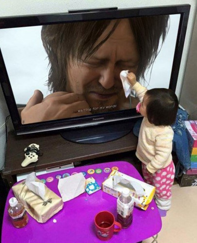 Một em bé đang lau những giọt nước mắt của một người đàn ông trên truyền hình.
