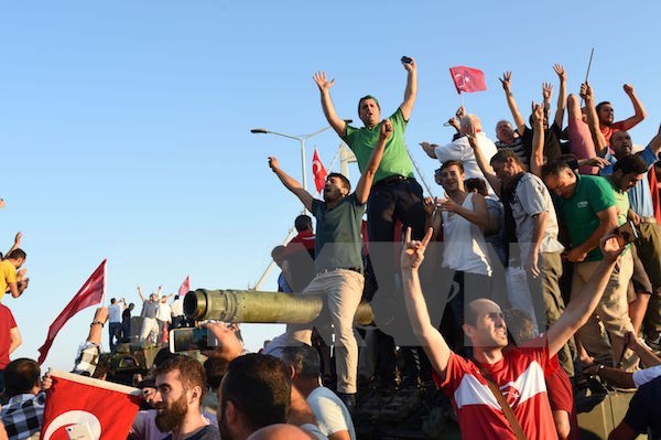 Người dân Thổ Nhĩ Kỳ sau khi giành quyền kiểm soát một vị trí do lực lượng đảo chính chiếm giữ trên cầu Bosphorus ở Istanbul. (Nguồn: AFP/TTXVN)