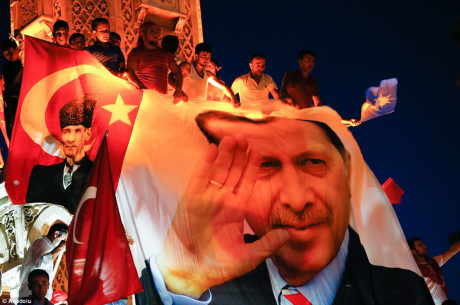 Người dân leo lên đỉnh của tượng đài ở thành phố ven biển Izmir để treo một poster khổng lồ của ông Erdogan. (Nguồn: DailyMail)