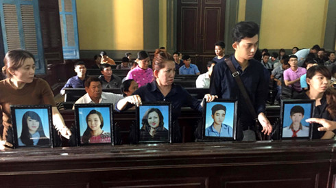 Gia đình nạn nhân đến dự tòa cùng di ảnh các nạn nhân bị giết hại trong vụ án - Ảnh: Thuận Thắng/Tuổi Trẻ
