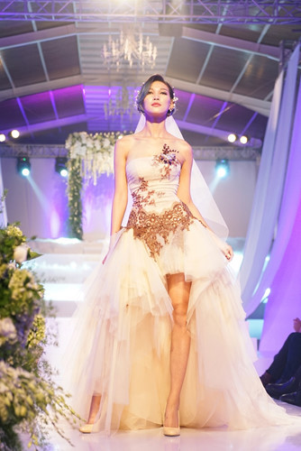 Diệp Minh Châu lạnh lùng sải bước trên sàn catwalk với thiết kế váy cưới chất liệu voan dáng ngắn với điểm nhấn là phần đuôi váy mềm mại, gợi vẻ nhẹ nhàng cho cô dâu.