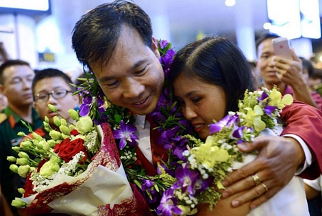 Xạ thủ Hoàng Xuân Vinh ôm lấy vợ - chị Hương Giang ngay khi vừa đặt chân xuống sân bay. (Ảnh: Zing)