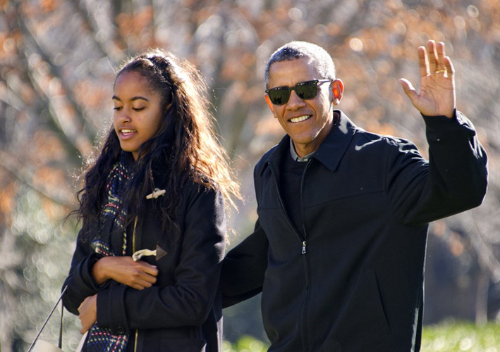 Tổng thống vẫy tay chào báo chí khi ông đi cùng con gái Malia trong chuyến du lịch Hawaii của gia đình hồi tháng 1 năm nay.