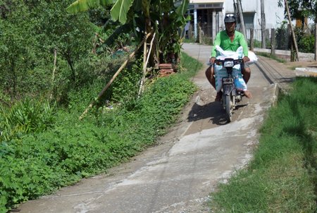 Đường giao thông nông thôn được đầu tư rất tốn kém nhưng sau đó không lâu đã sắp tuột xuống sông, nếu địa phương không có giải pháp gia cố kịp thời. Ảnh chụp tại một xã NTM huyện Mang Thít. 