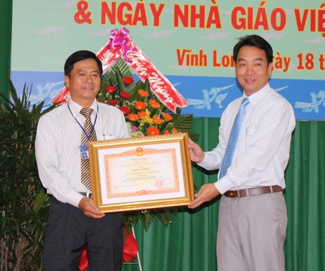 Ông Lữ Quang Ngời trao bằng khen của Thủ tướng Chính phủ cho lãnh đạo Trường CĐ Kinh tế- Tài chính Vĩnh Long.