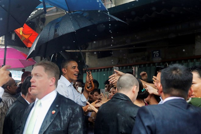 Trưa 24/5, trên đường ra sân bay Nội Bài, Tổng thống Obama cùng đầu bếp Anthony Bourdain bất ngờ dừng ở một quán trà đá ở làng Mễ Trì dù trời đổ mưa. (Ảnh: Reuters)