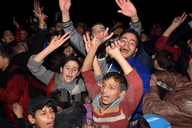 Bước ngoặt lớn trong cuộc chiến tại Syria: Người dân Syria đổ ra đường mừng vui sau khi thành phố Aleppo được giải phóng hoàn toàn ngày 22/12. (Nguồn: AFP/TTXVN)