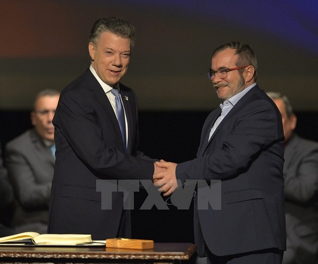 Colombia đạt thỏa thuận hòa bình lịch sử: Ngày 24/11, Tổng thống Colombia Juan Manuel Santos (trái) và Thủ lĩnh tối cao Lực lượng vũ trang Cách mạng Colombia (FARC) Rodrigo Londono (phải) đã ký thỏa thuận hòa bình sửa đổi nhằm chấm dứt cuộc nội chiến kéo dài 52 năm ở nước này. (Nguồn: AFP/ TTXVN)