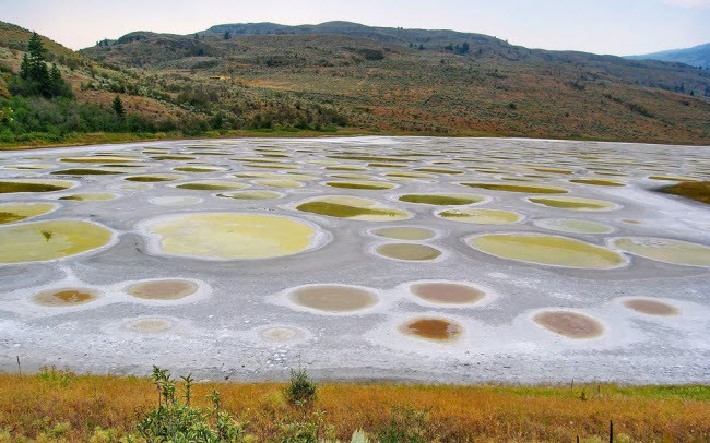 Hồ Đốm (Spotted) nằm gần sa mạc Osoyoos ở bang British Columbia, Canada. Vào mùa hè, hầu hết nước trong hồ bốc hơi hết, để lại trên bề mặt các loại khoáng chất. Những khoáng chất này tạo thành những chấm bi lớn. Tùy theo lượng khoáng chất và sự kết hợp của các chất hóa học với nhau, các chấm bi này sẽ đổi màu.