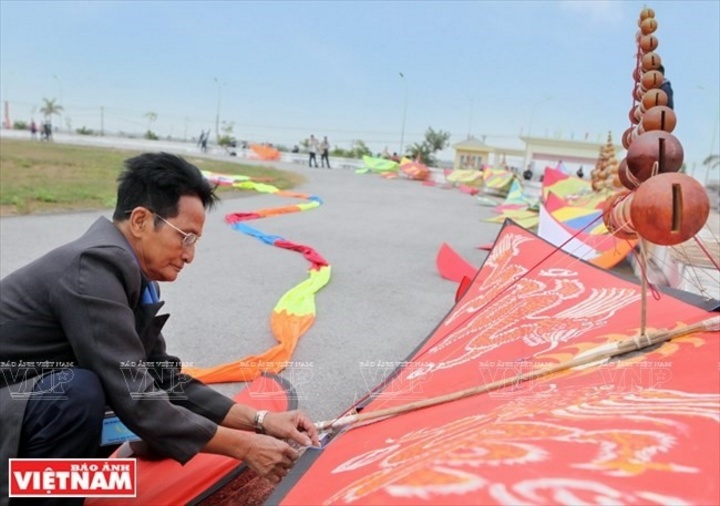 Một người chơi cao niên đang lắp ráp diều sáo tại sân vận động huyện Thanh Oai.