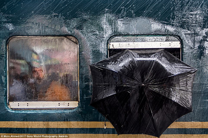Một ánh mắt tò mò qua ô cửa sổ của chuyến tàu khởi hành từ ga Tongi (Bangladesh) trong một ngày mưa gió.