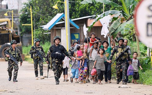 Quân nhân Philippines đi cạnh dân thường ở thành phố Marawi. Ảnh: Philstar.