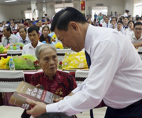 Bí thư Tỉnh ủy- Trần Văn Rón trao tặng Mẹ Việt Nam anh hùng Trần Thị Tư Biên quyển sách.