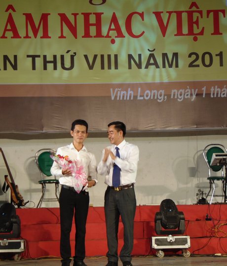 Ông Lê Thanh Hiền- Phó Giám đốc Sở VH, TT và DL Vĩnh Long (bìa phải) tặng hoa chúc mừng và động viên nhạc sĩ trẻ Phạm Duy Phương.