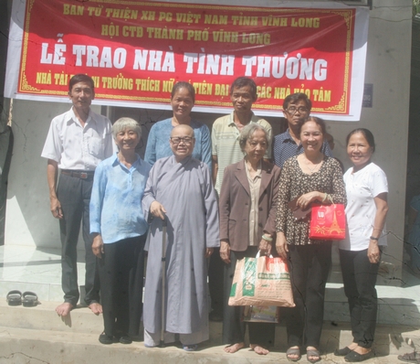 Ni trưởng Thích Nữ Trí Tiên chụp ảnh lưu niệm cùng chính quyền địa phương và gia đình bà Út Em.