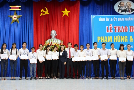 Ông Nguyễn Minh Dũng, Phó Chủ tịch HĐND tỉnh cùng đại diện nhà tài trợ trao học bổng cho các em.
