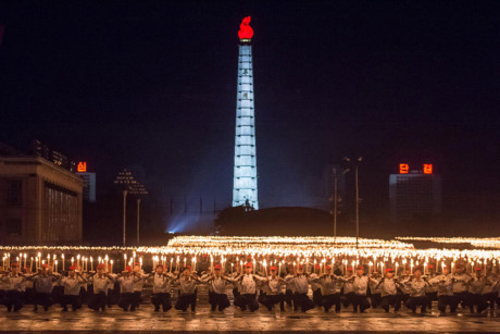 Các tình nguyện viên tham gia màn biểu diễn đuốc tại quảng trường Kim Nhật Thành vào đêm 10/10/2015. Đằng xa phía sau họ là tháp Chủ thể (Juche). Ảnh: AFP.