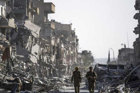 Chiến binh SDF đi tuần dọc theo một con phố ở Raqqa.