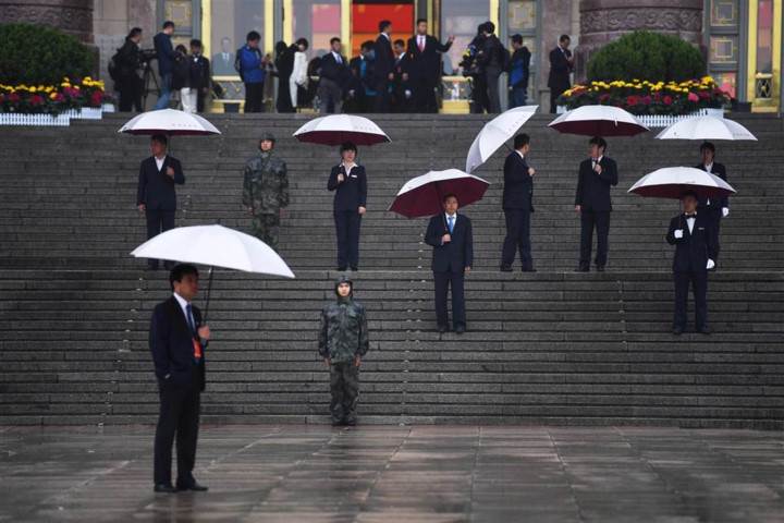 Đội ngũ nhân viên lễ tân cầm ô đứng trước Đại lễ đường Nhân dân để đón các đại biểu. Ảnh: AFP/Getty.